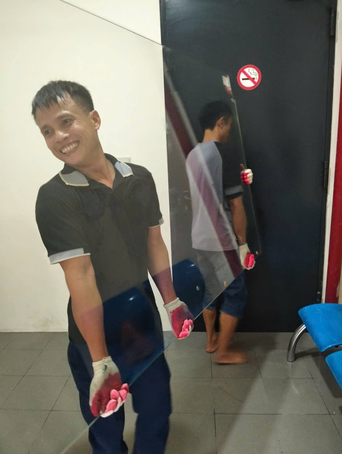 Nhân viên cẩn thận vận chuyển tấm kính vào bên trong công trình